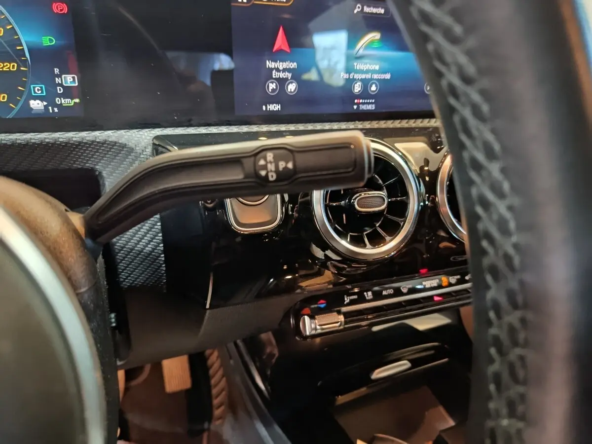 Gros plan sur la commande de boîte automatique et tableau de bord noir brillant de la Mercedes Classe A bleu hybride rechargeable.