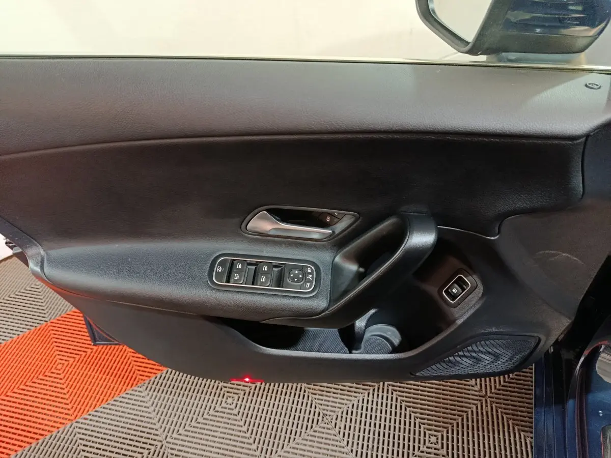 Vue intérieure côté gauche de la porte avant d'une Mercedes Classe A 250 e Business Line bleue avec commandes électriques.