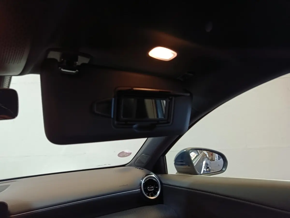 Vue intérieure côté droit de la Mercedes Classe A 250 e Business Line 2021, avec pare-soleil ouvert et rétroviseur bleu visible.