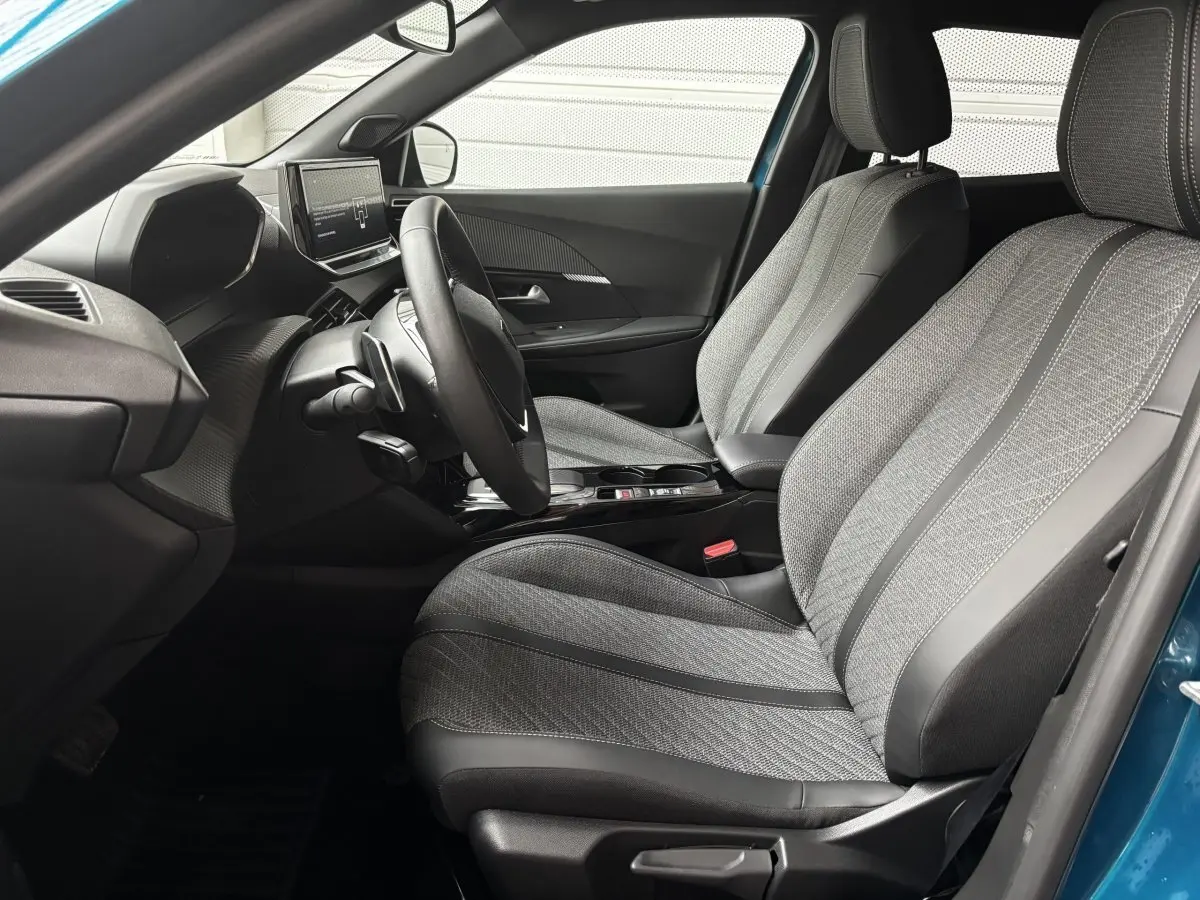 Vue intérieure côté conducteur du Peugeot 2008 Hybrid 145 e-DCS6 Allure bleu, mettant en valeur les sièges et le tableau de bord moderne.