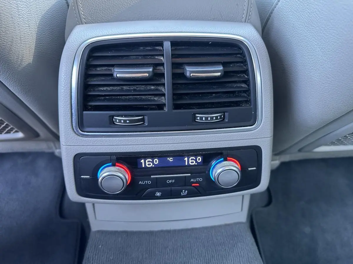 Gros plan sur la commande de climatisation automatique arrière bi-zone de l'Audi A6 gris, avec réglages à 16°C.