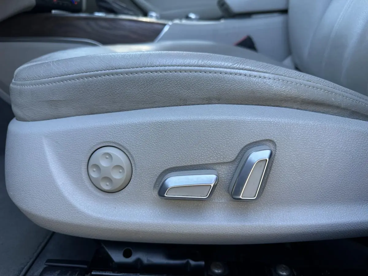 Gros plan sur les commandes de réglage électrique du siège avant en cuir gris clair de l'Audi A6 2.0 TFSI Ambiente.