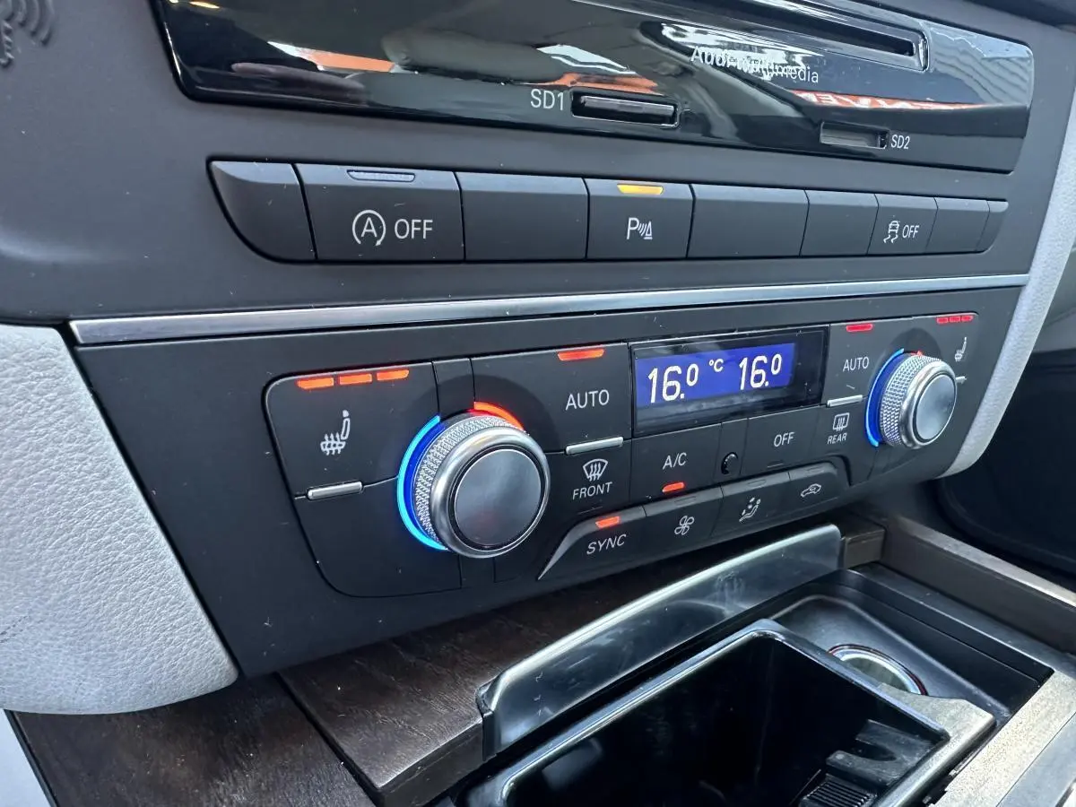 Détail de la console centrale de l’Audi A6 2015 montrant la climatisation automatique 4 zones avec réglages à 16°C.