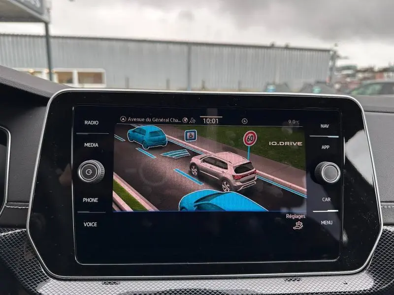 Écran tactile intérieur montrant l'aide au stationnement du Volkswagen T-Cross jaune vue de trois quarts arrière.