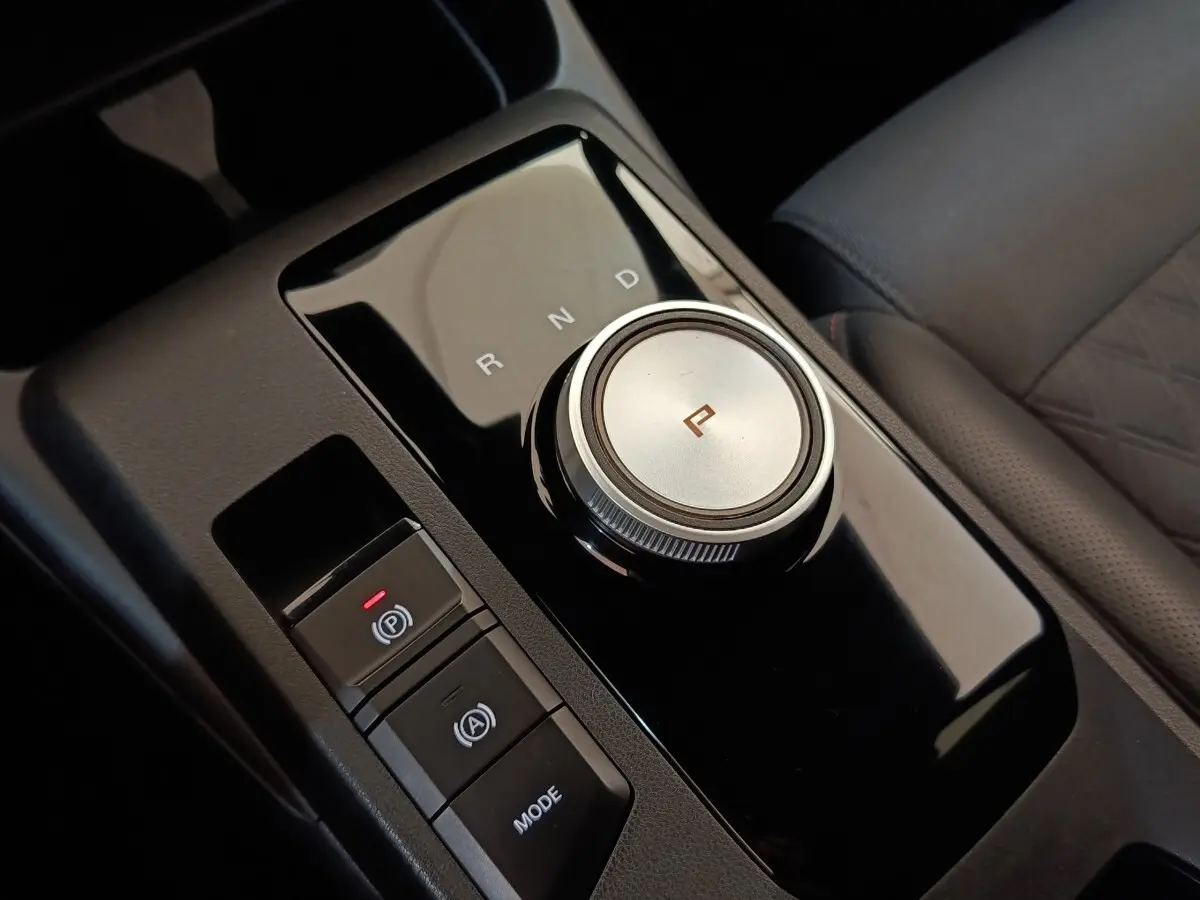 Gros plan sur la molette de boîte automatique et commandes noires du levier de vitesses intérieur d’une MG3 gris foncé.