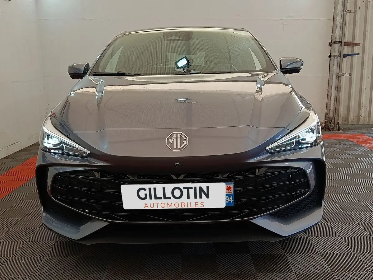 Vue avant d'une MG3 gris foncé 2024 avec phares LED allumés et large calandre noire brillante.