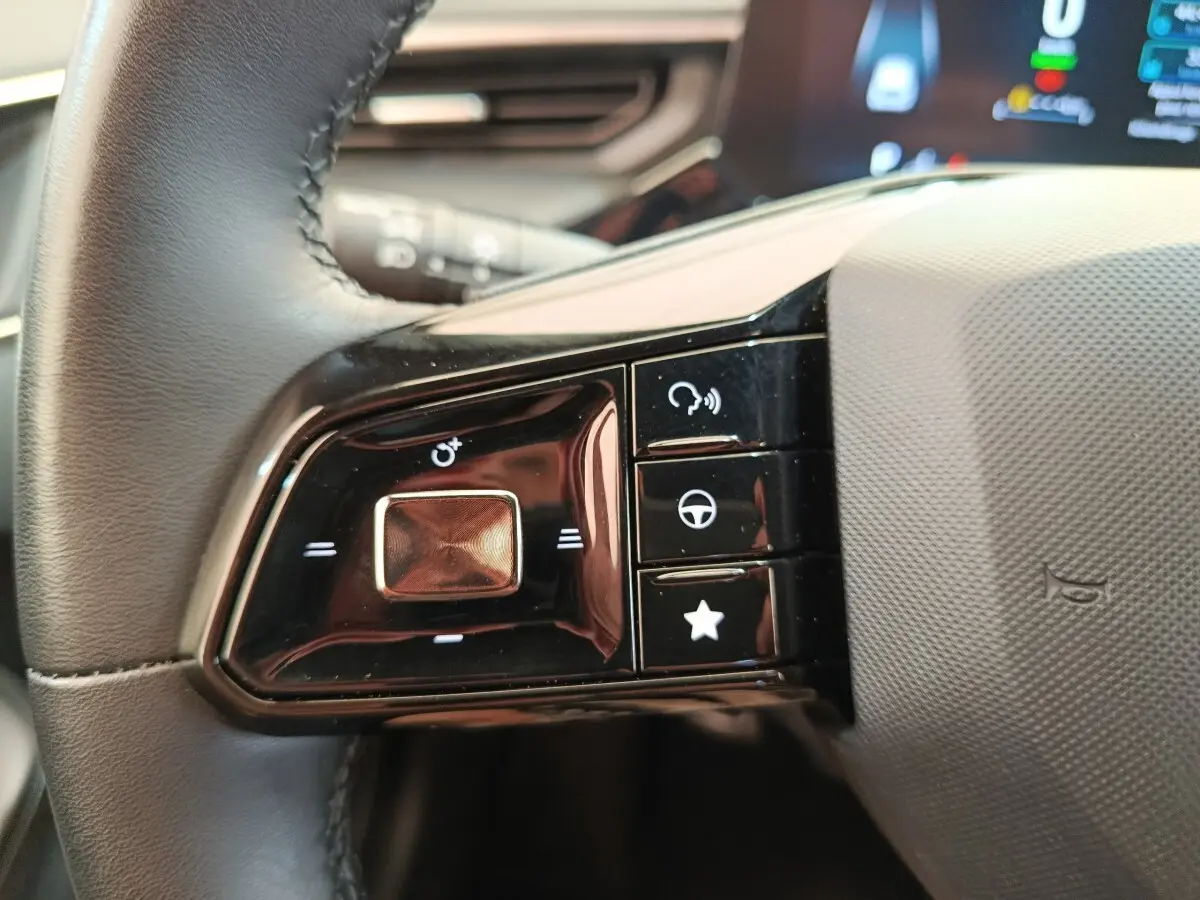 Gros plan sur les commandes multifonctions noires du volant côté gauche du MG3 gris foncé 2024.
