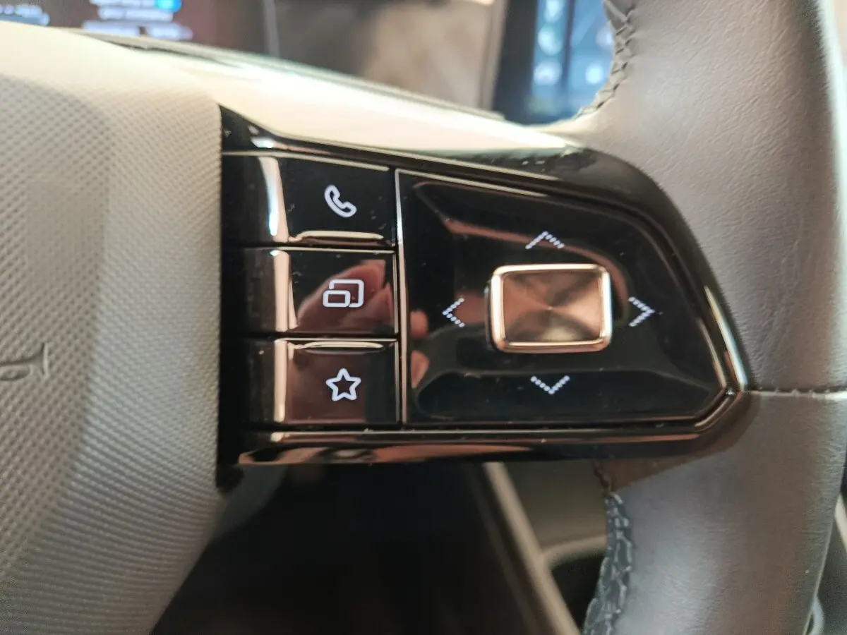Gros plan sur les commandes noires multifonctions au volant cuir du MG3 gris foncé 2024, côté droit.
