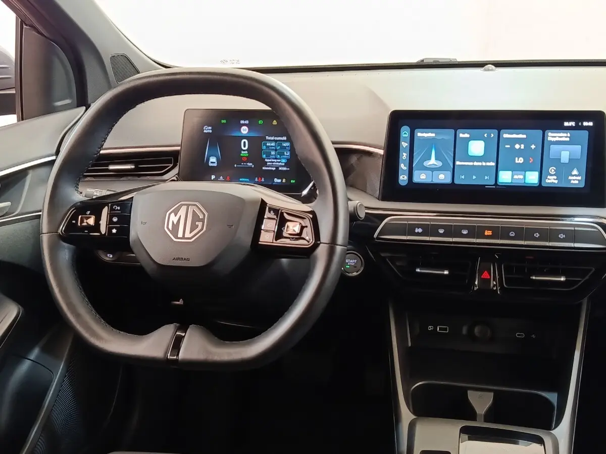 Vue intérieure centrée sur le volant noir et les écrans digitaux du tableau de bord du MG3 gris foncé 2024.