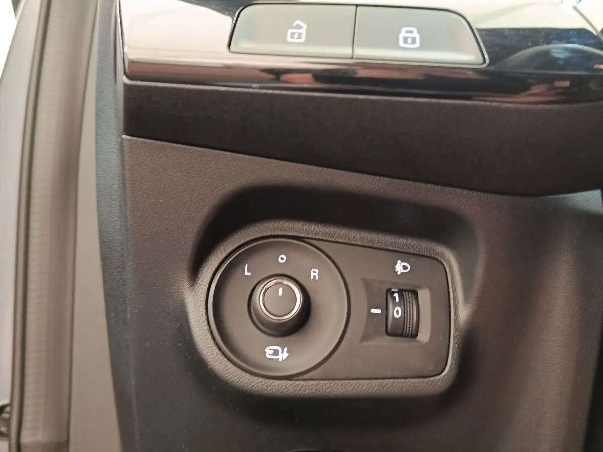 Commande de réglage des rétroviseurs et des phares sur le panneau intérieur côté conducteur d'une MG3 gris foncé 2024.