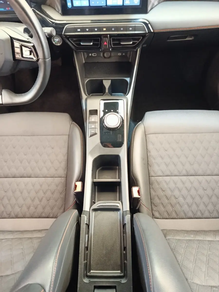 Vue plongeante sur la console centrale et les sièges gris foncé avec surpiqûres orange du MG3 2024 Hybrid+ Luxury.