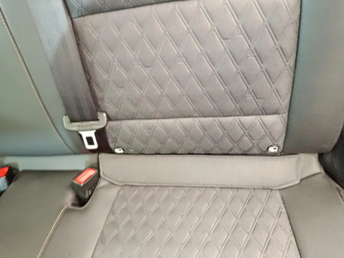 Gros plan sur la banquette arrière gris foncé matelassée du MG3 1.5L Hybrid+ Luxury 2024 avec ceinture de sécurité visible.