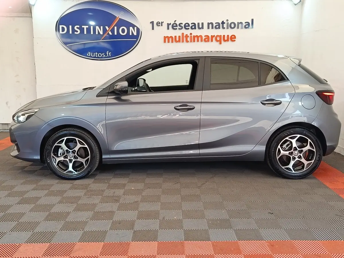 Vue latérale droite d'une MG3 gris foncé 2024 avec jantes alliage et lignes épurées, en intérieur showroom.