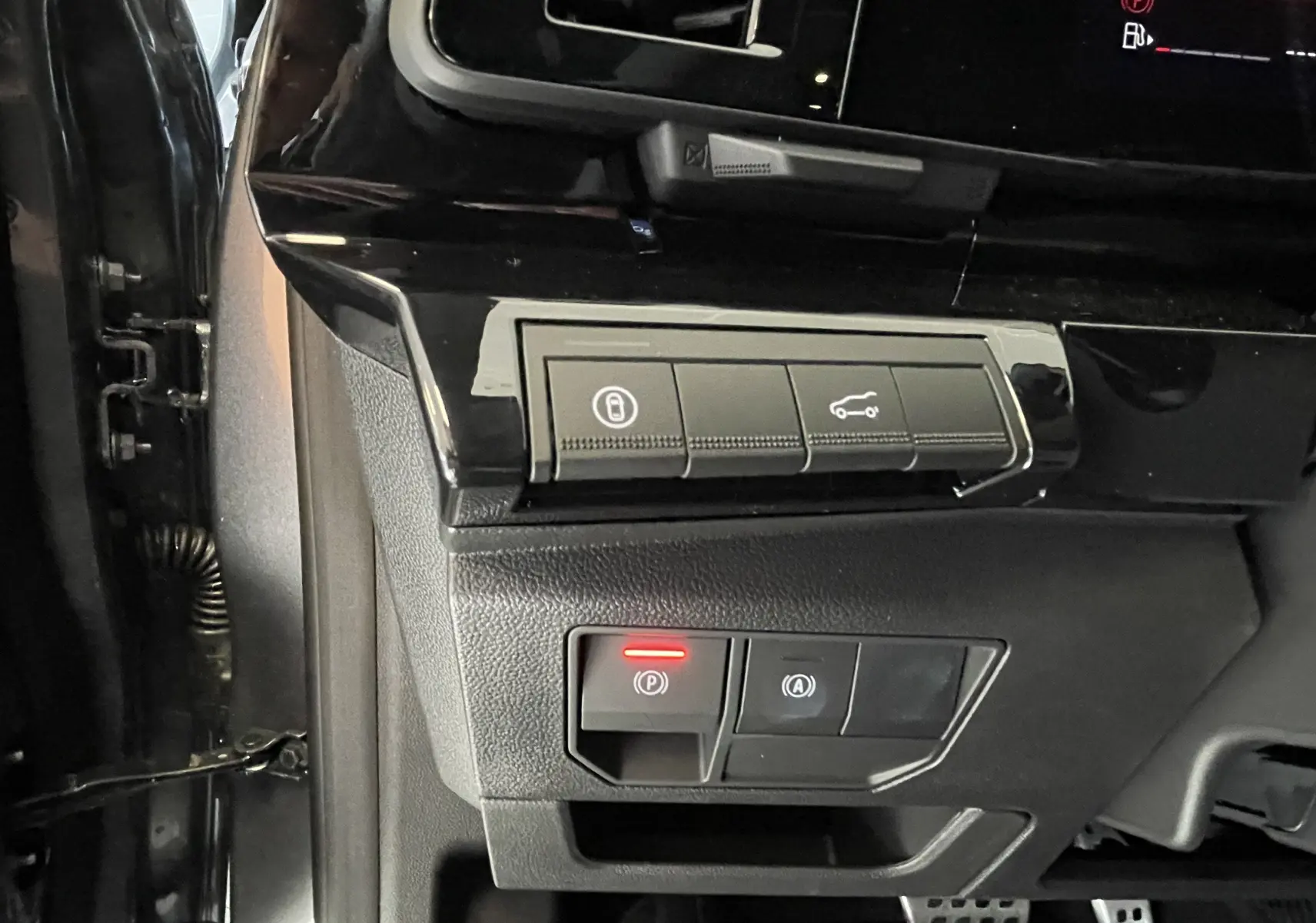 Gros plan sur les commandes de verrouillage et frein à main électrique à gauche du volant dans le Renault Rafale gris shiste.