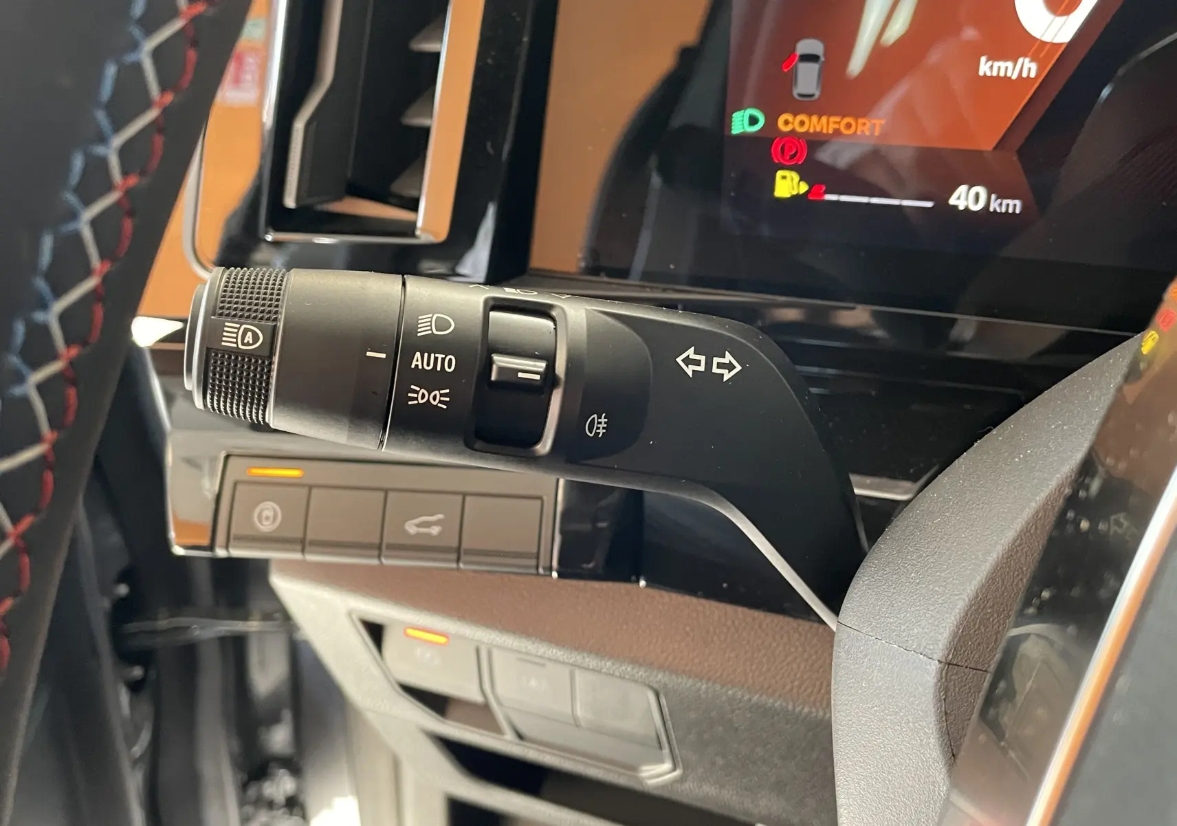 Gros plan sur la commande des feux et clignotants à gauche du volant dans le tableau de bord du Renault Rafale gris shiste 2024.