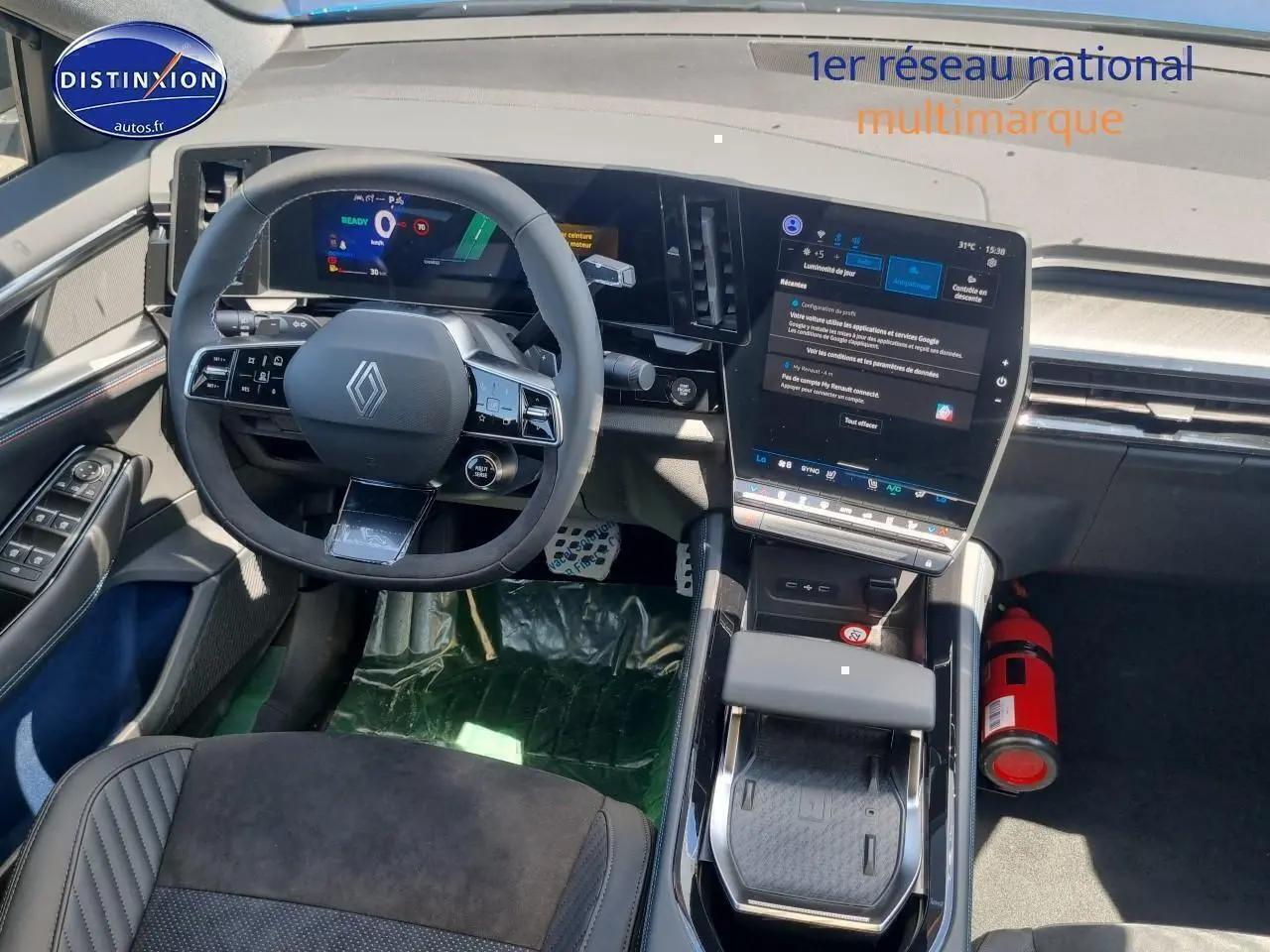 Vue intérieure avant du tableau de bord et volant Renault Rafale bleu sommet avec écran tactile vertical et accoudoir central.