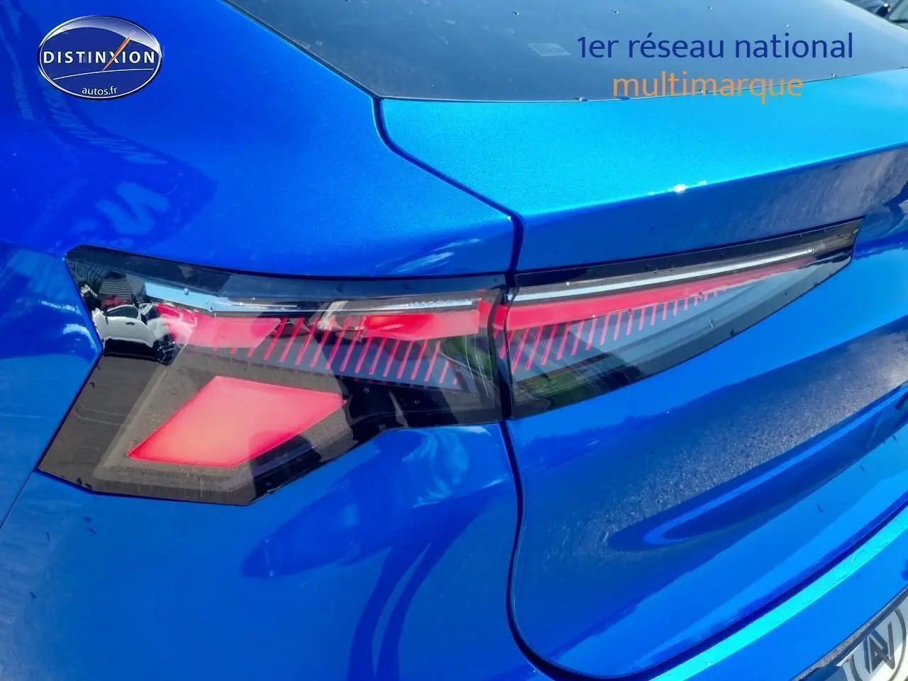 Feu arrière droit allumé sur Renault Rafale bleu sommet, vue rapprochée du coffre et du hayon arrière.