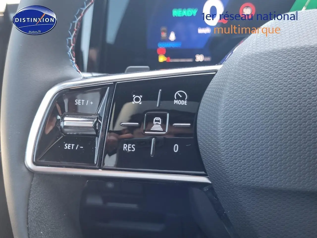 Gros plan sur les commandes multifonctions à gauche du volant du Renault Rafale bleu sommet hybride 2025.