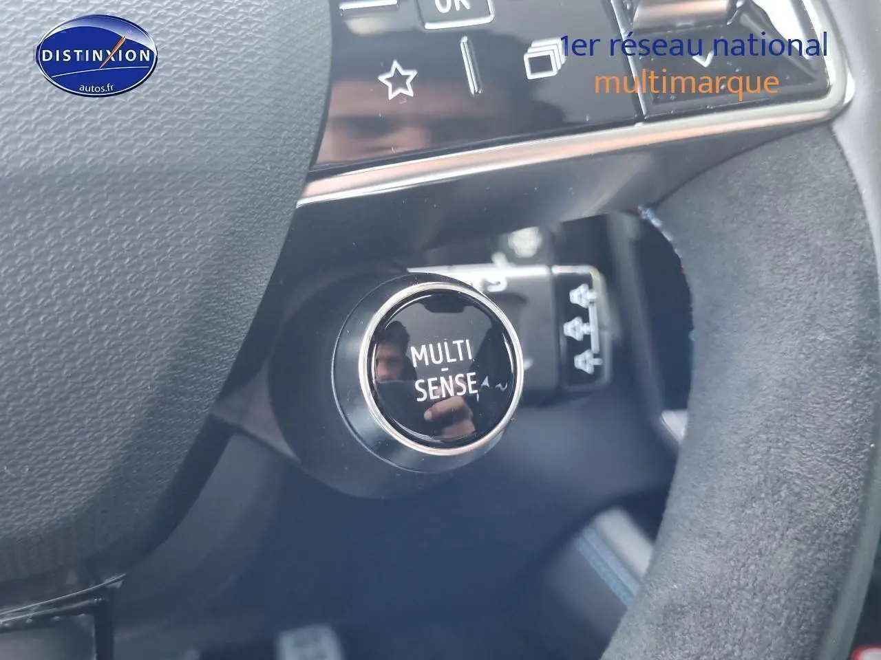 Gros plan sur le bouton Multi Sense dans l'habitacle du Renault Rafale bleu sommet, côté conducteur.