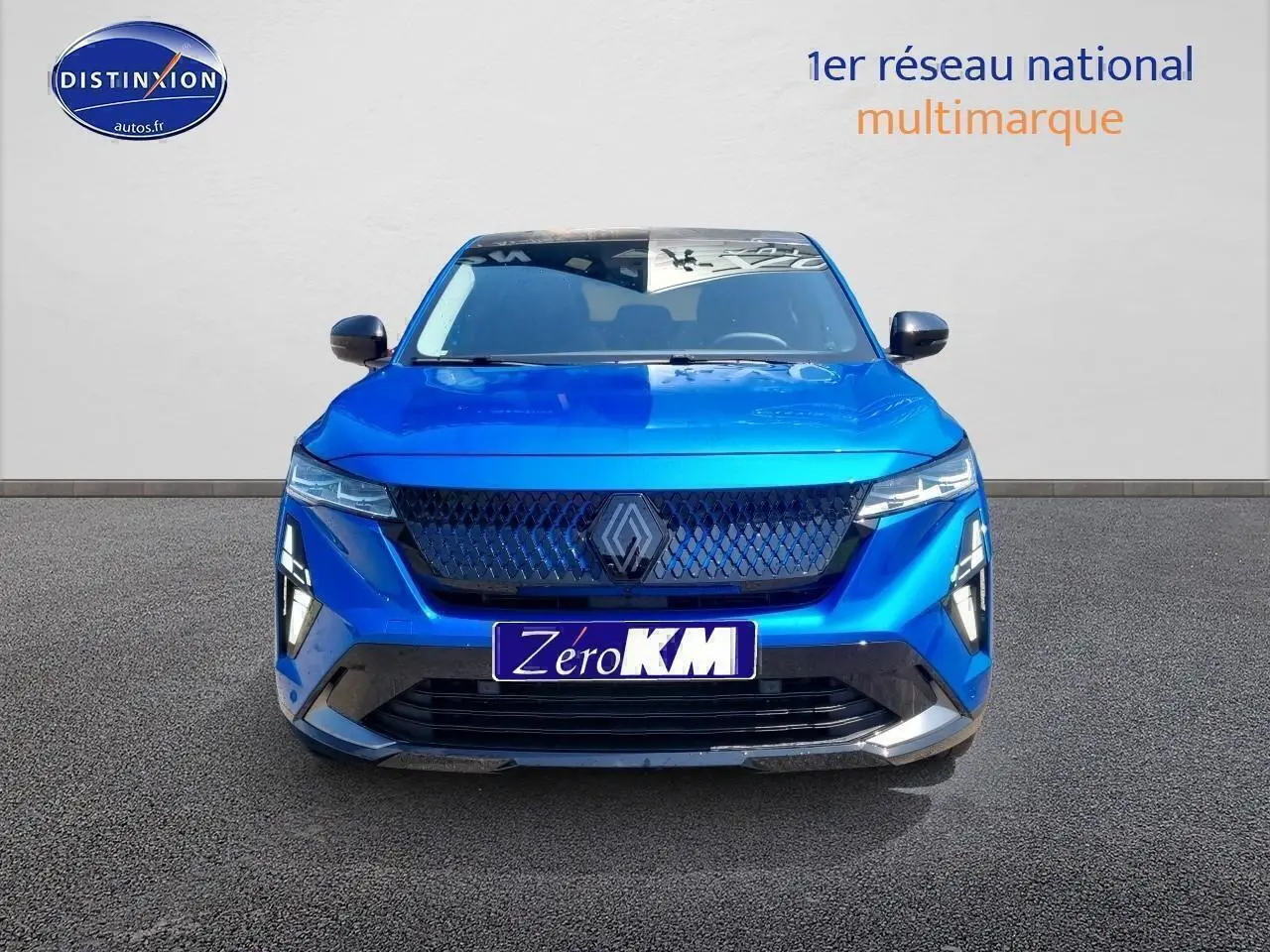 Vue de face d'une Renault Rafale bleu sommet avec calandre noire et feux LED fins allumés.