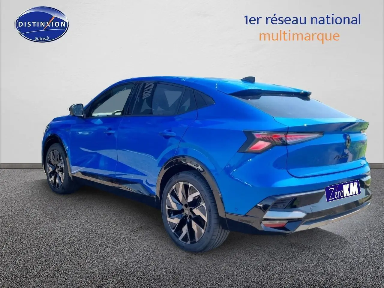 Vue 3/4 arrière droite d'un Renault Rafale bleu sommet avec jantes alliage et becquet arrière sportif.