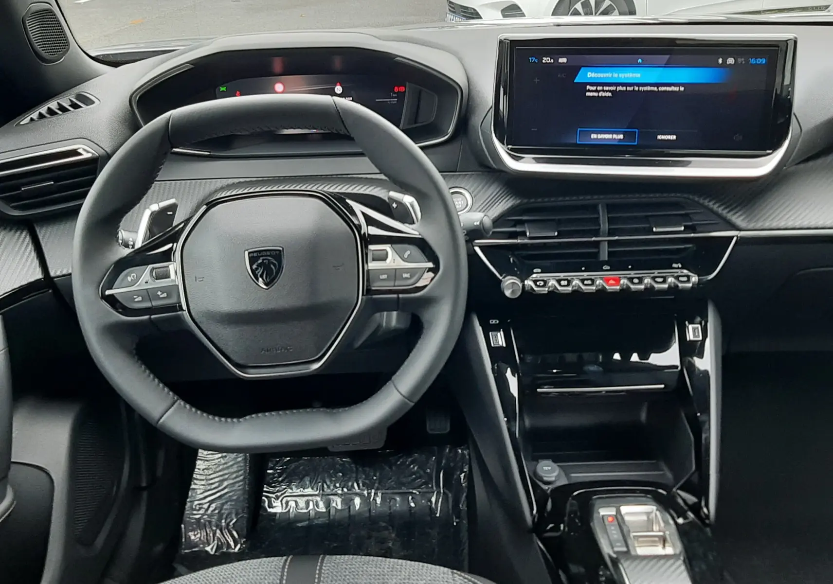 Intérieur Peugeot 2008 2025 en gris, vue frontale sur le volant compact et l'écran tactile du tableau de bord.