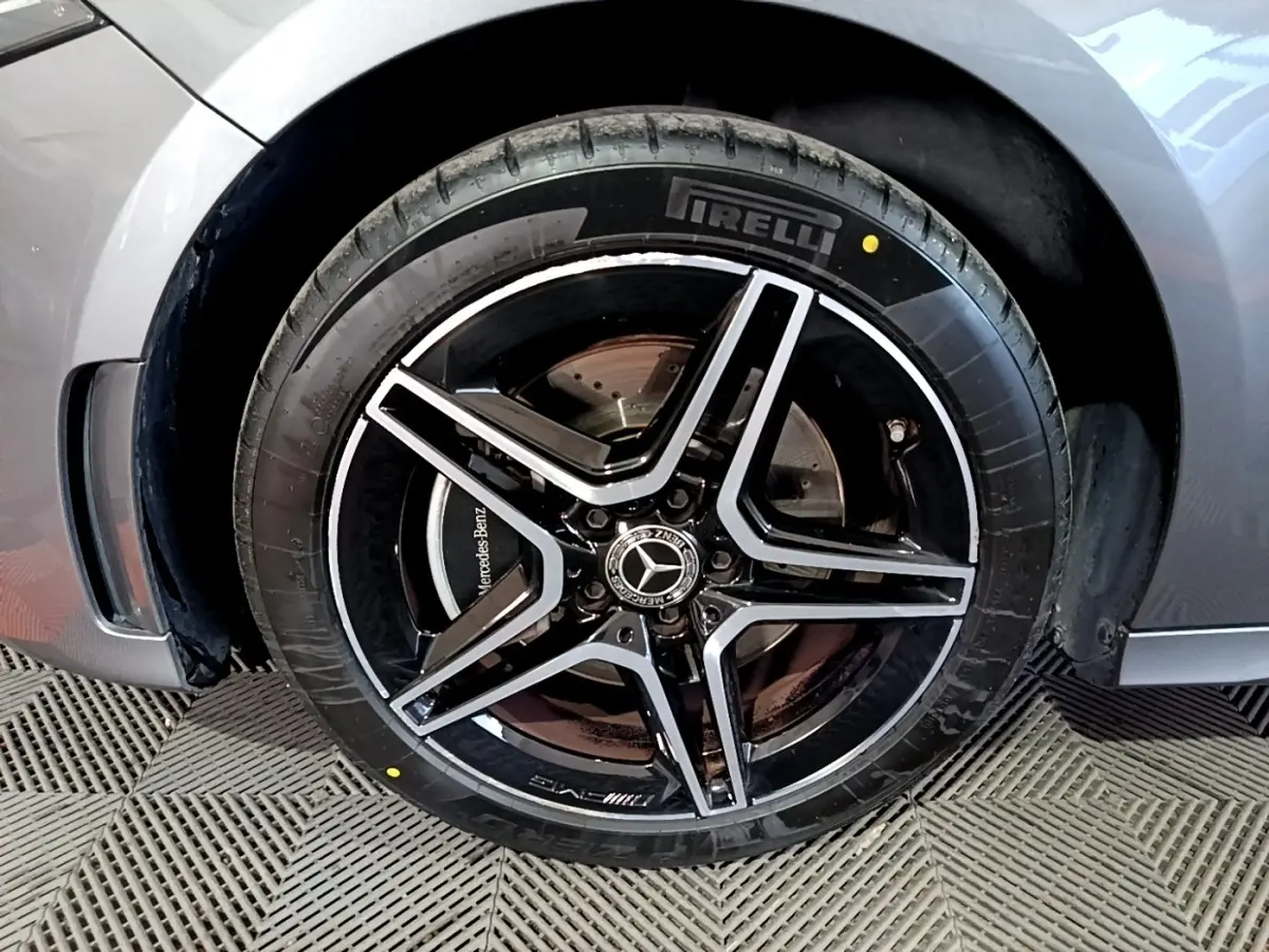 Gros plan sur la roue avant droite gris foncé d'une Mercedes Classe A 250 e AMG Line avec jante AMG noire et argent.