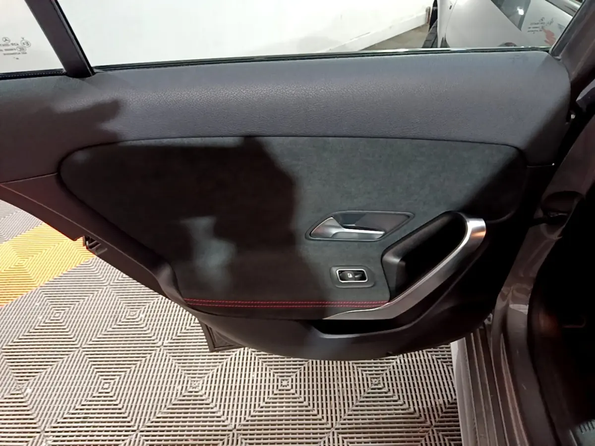 Porte arrière droite de Mercedes Classe A 250 e AMG Line 2021, garniture noire avec surpiqûres rouges et poignée alu.