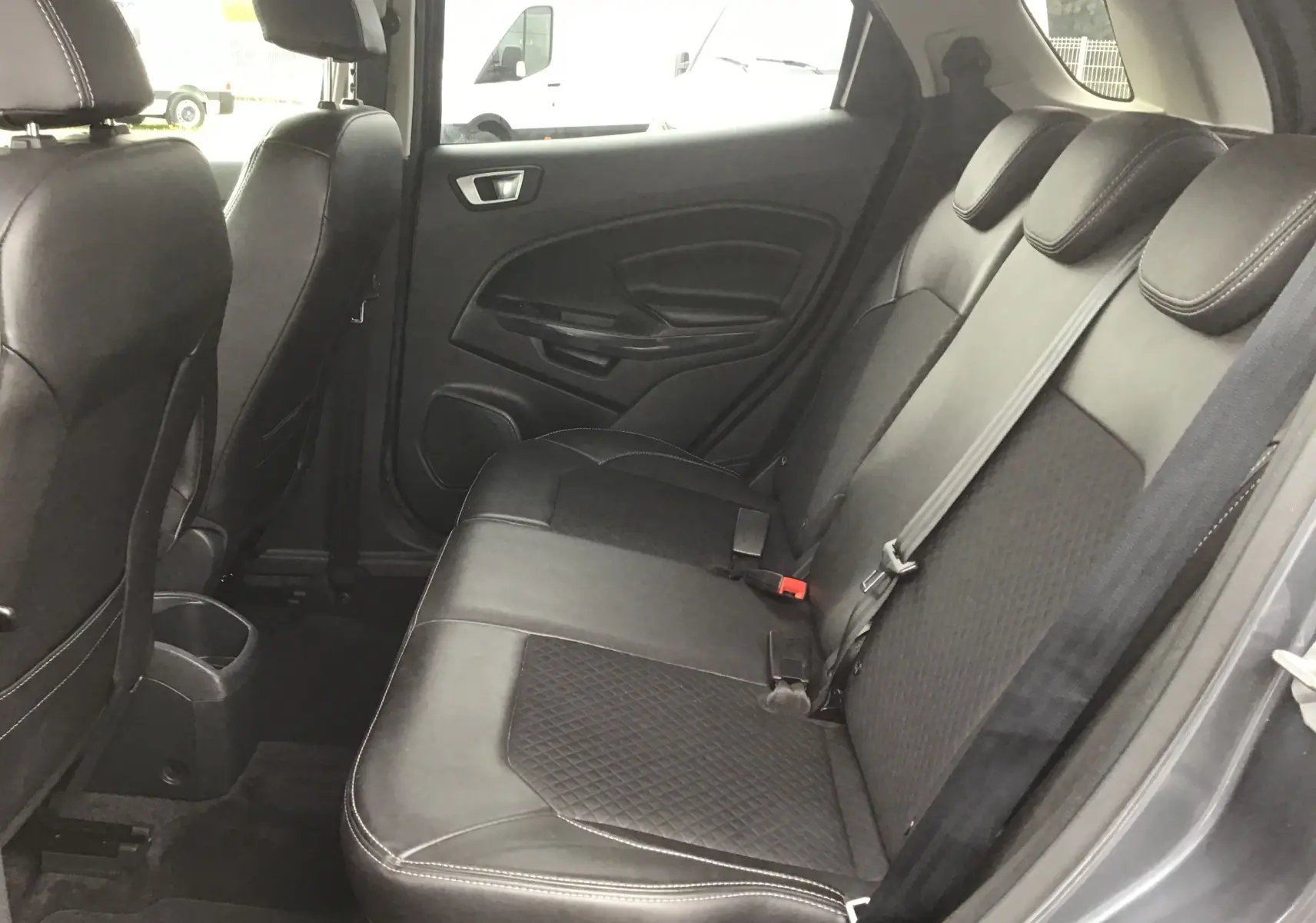 Vue intérieure côté droit des sièges arrière en cuir noir avec surpiqûres blanches du Ford EcoSport gris foncé 2017.