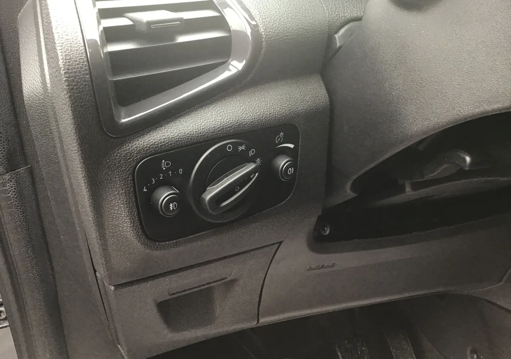 Détail du tableau de bord côté gauche du Ford EcoSport gris foncé, montrant les commandes d’éclairage et la ventilation.