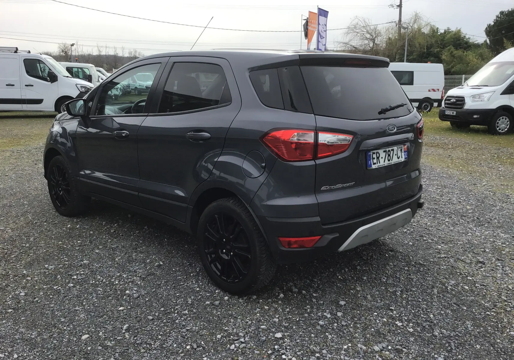 Ford EcoSport gris foncé métal vu en 3/4 arrière droit, avec jantes noires et vitres teintées.
