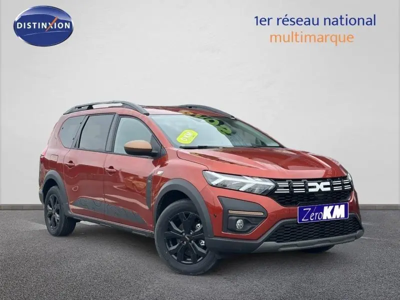 Dacia Jogger brun Terracota métallisé en 3/4 avant droit avec jantes noires et barres de toit visibles.