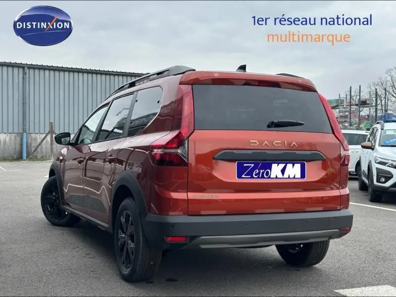 Vue 3/4 arrière droite du Dacia Jogger 2024 brun Terracota métallisé avec barres de toit et jantes noires.