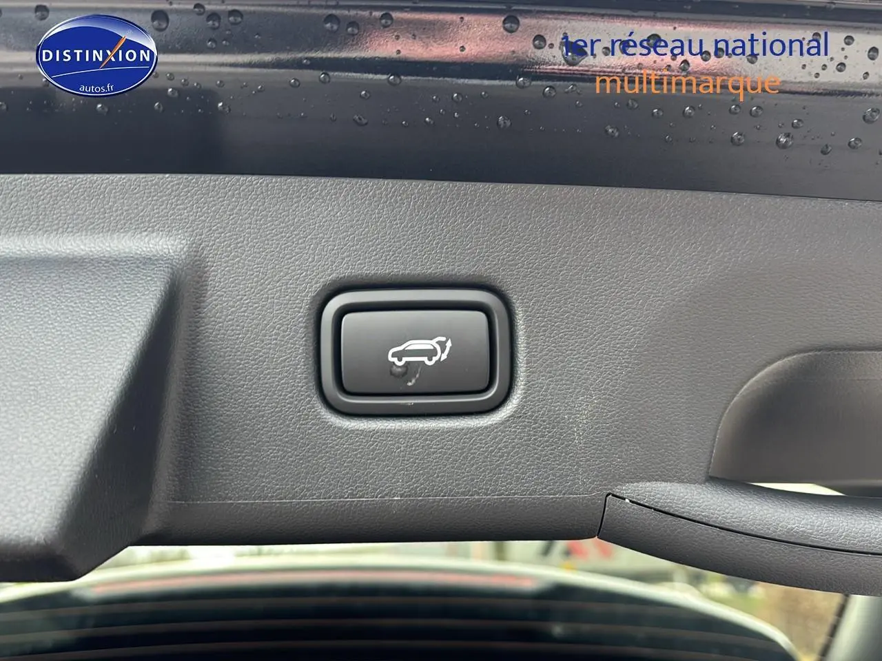 Bouton d'ouverture électrique du hayon sur intérieur noir du Hyundai Tucson 2026 vue rapprochée du coffre ouvert.