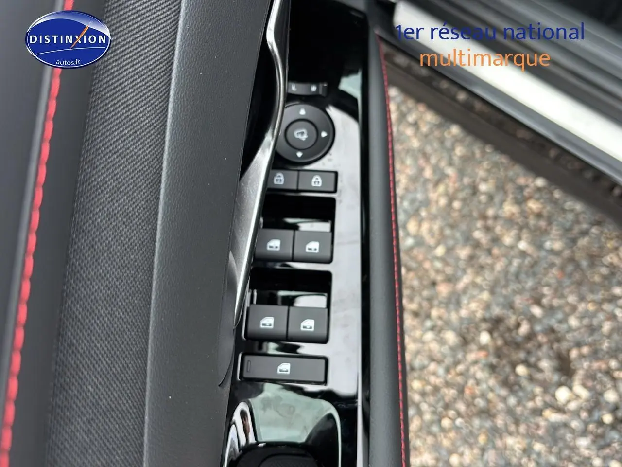 Détail de la commande des vitres côté conducteur avec surpiqûres rouges sur porte noire d’un Hyundai Tucson 2026.