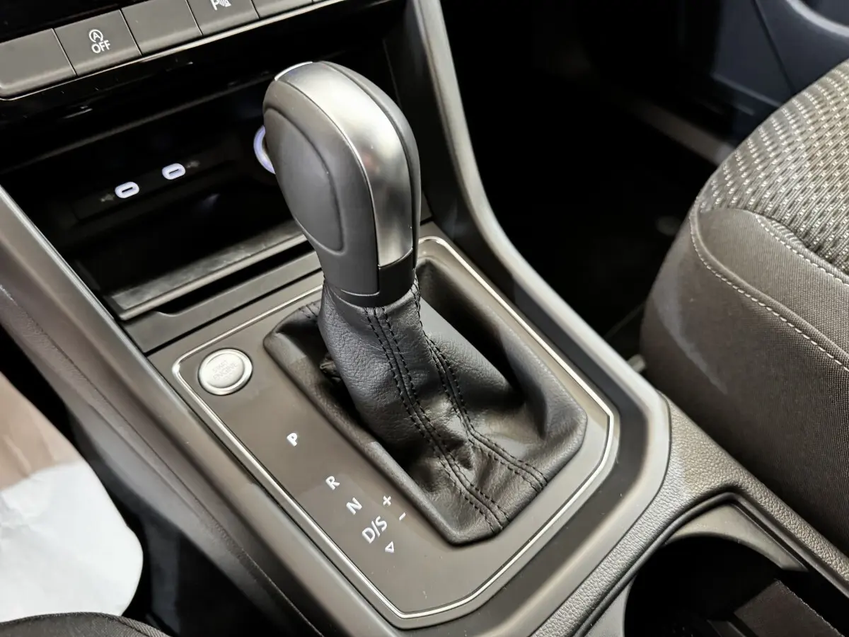 Gros plan sur la commande de boîte automatique noire et levier de vitesse dans l'habitacle du Volkswagen Touran 2024.