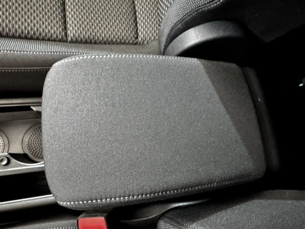 Gros plan sur l'accoudoir central tissu gris et les sièges arrière en tissu du Volkswagen Touran 2024.