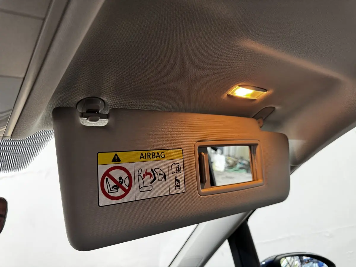 Détail du pare-soleil côté conducteur avec miroir éclairé dans un Volkswagen Touran bleu 2024.