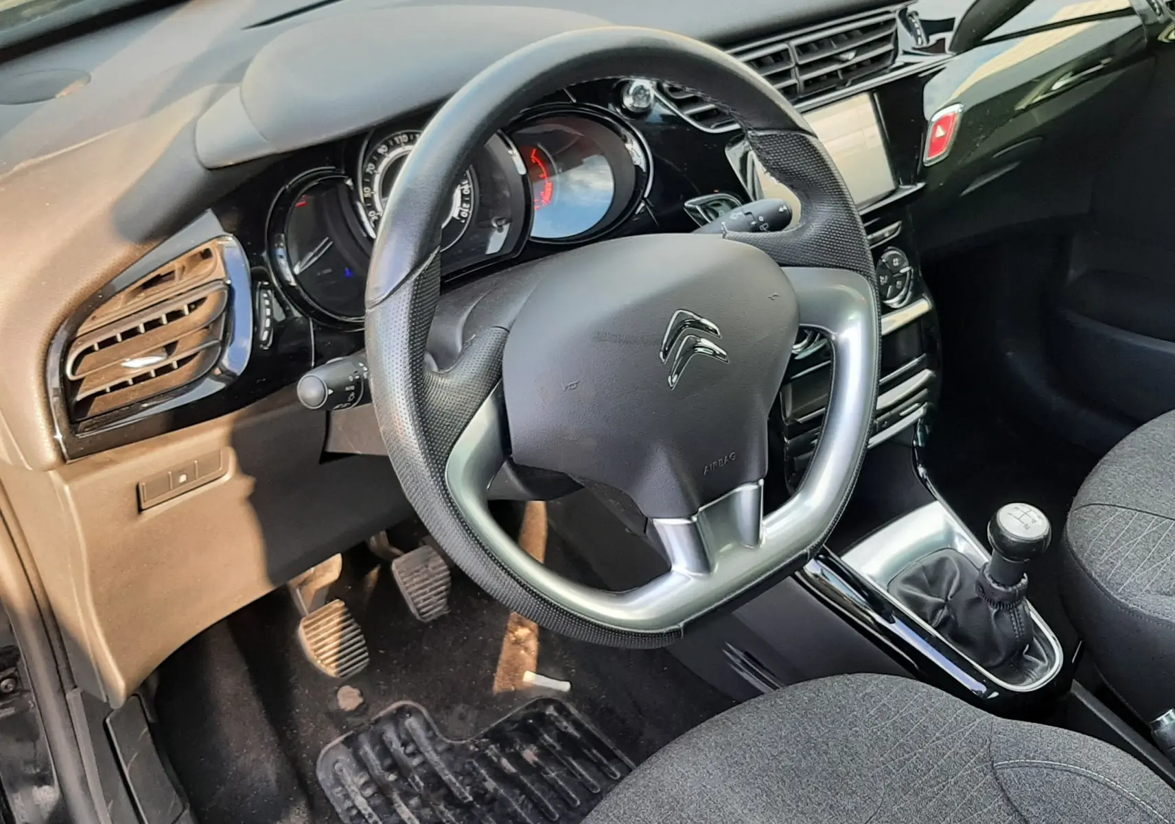 Vue intérieure côté conducteur du tableau de bord noir et volant Citroën C3 BlueHDi 2016 avec boîte manuelle.