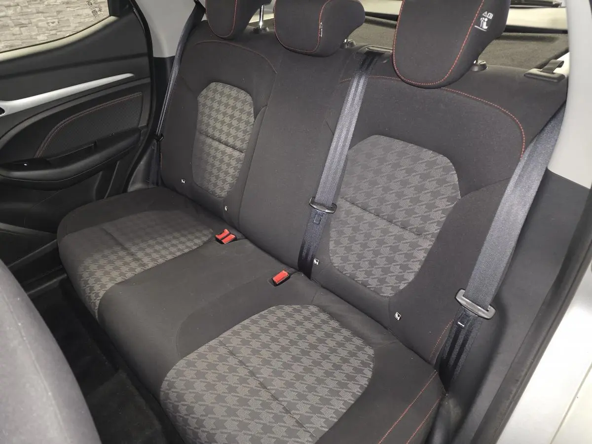 Vue intérieure de la banquette arrière en tissu noir et gris du MG ZS 2023, avec appuie-têtes et ceintures de sécurité visibles.