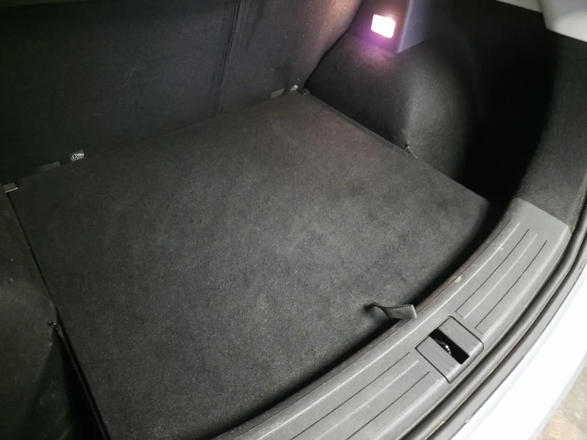 Coffre ouvert de MG ZS 2023, vue intérieure montrant le tapis noir et l’éclairage du coffre allumé.