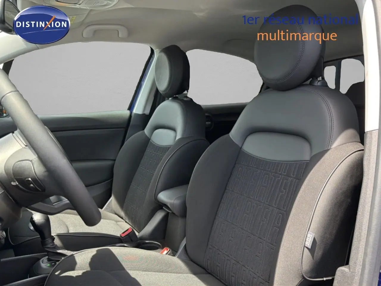 Intérieur de la FIAT 500X 2024, vue côté gauche sur les sièges avant en cuir noir avec motifs FIAT embossés.