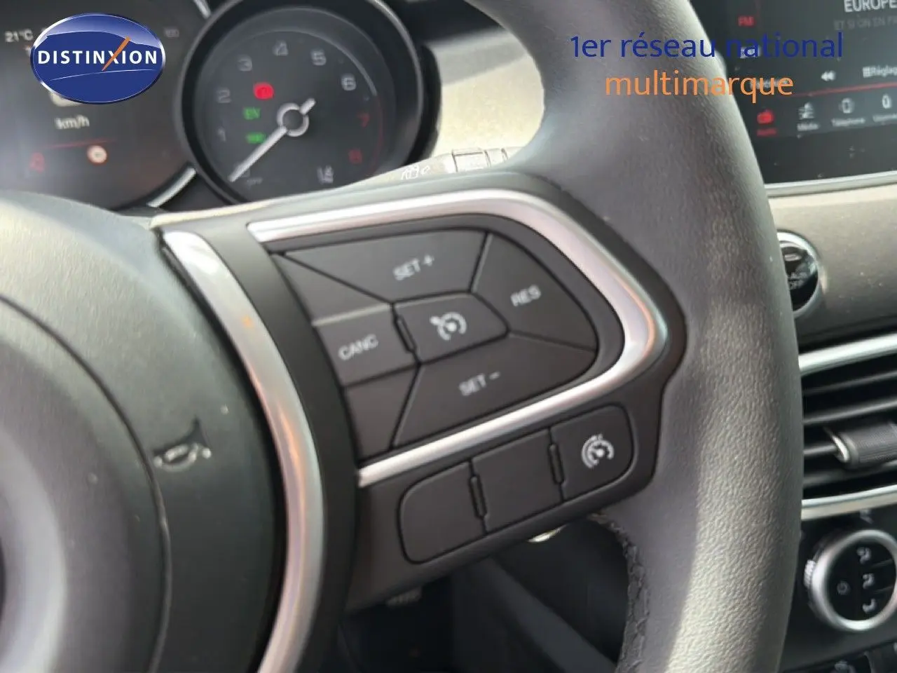 Détail du volant côté gauche avec commandes de régulateur de vitesse sur FIAT 500X 2024 hybride.