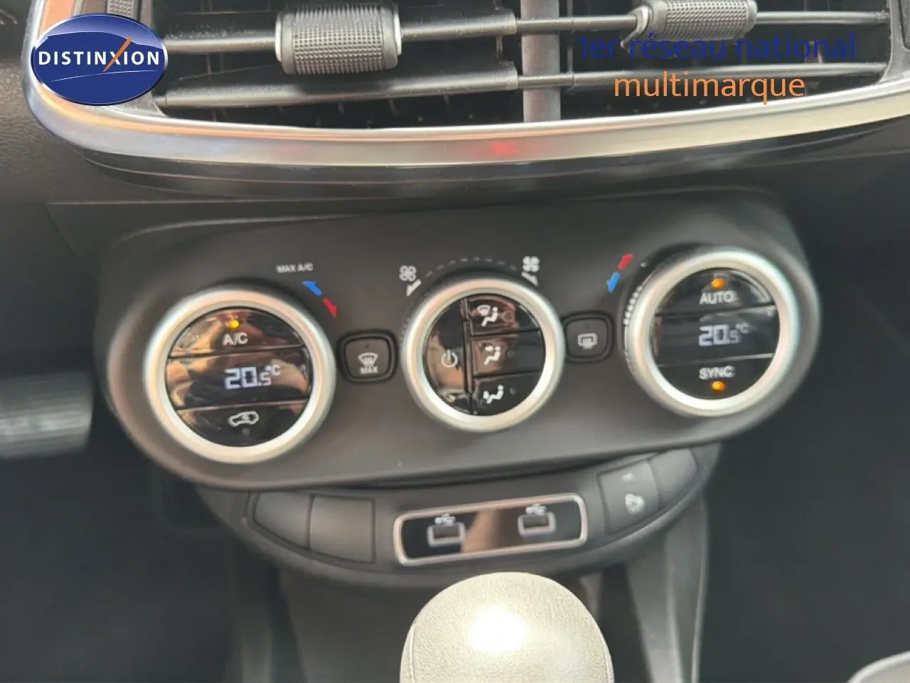 Gros plan sur la console centrale de la Fiat 500X 2024, montrant les commandes de climatisation digitales et la boîte automatique.
