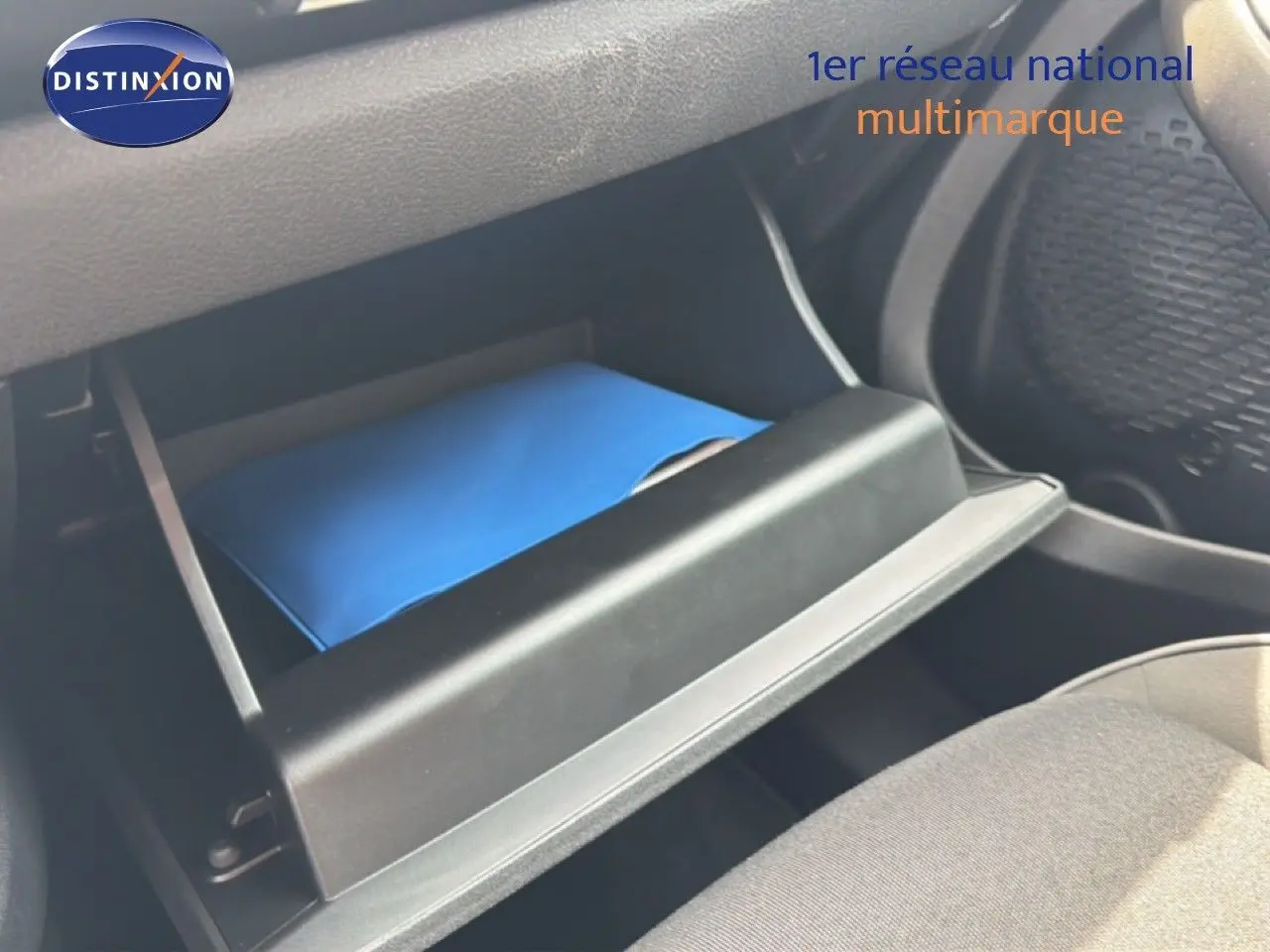 Gant de boîte à gants ouvert montrant un document bleu dans une Fiat 500X 2024, intérieur noir.