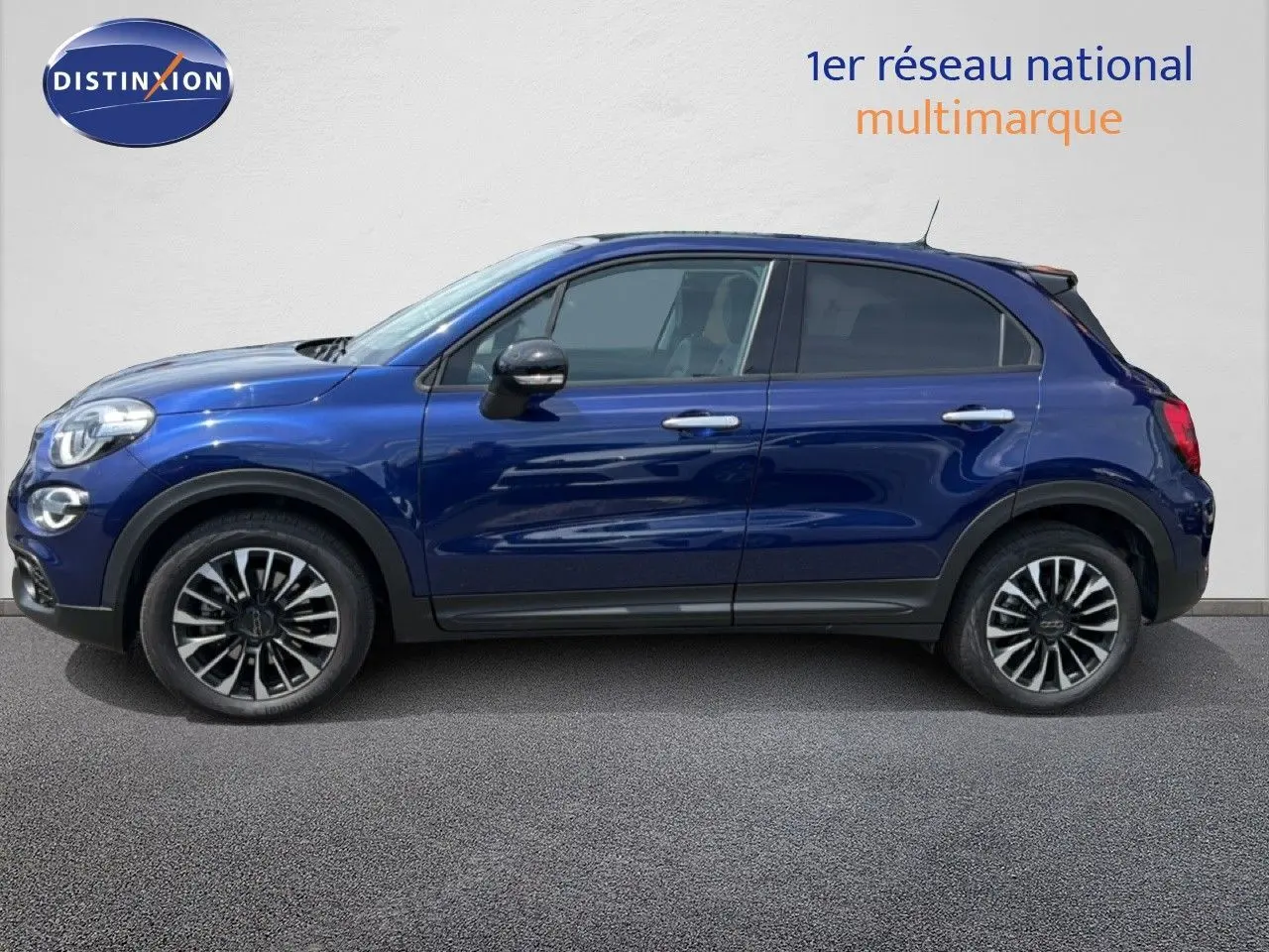Vue latérale droite du FIAT 500X bleu Venezia 2024 avec jantes alliage bicolores et détails noirs contrastants.