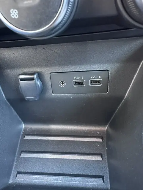 Gros plan sur la console centrale noire de la Renault Clio V Blue dCi 2025, montrant deux ports USB et une prise 12V.