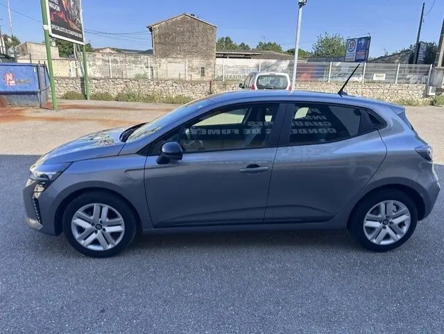 Profil droit d'une Renault Clio gris 2025 avec vitres surteintées et jantes alliage cinq branches.
