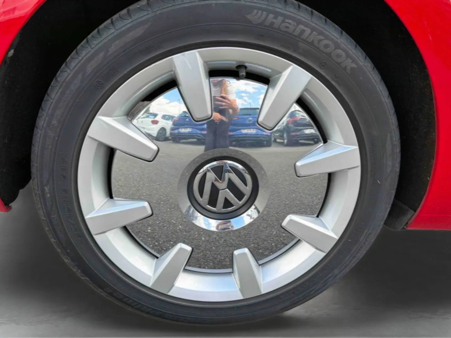 Gros plan sur la jante 18 pouces Disc argentée d’une Volkswagen Coccinelle rouge Tornade, avec pneu Hankook visible.