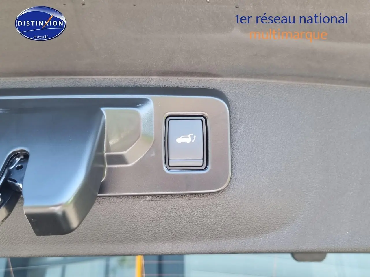 Bouton d'ouverture électrique du coffre sur la garniture intérieure du hayon d'une Renault Rafale noir étoile.